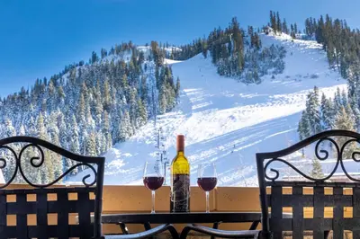 a table with two glasses of wine and a bottle at The Village at Palisades Tahoe in Olympic Valley