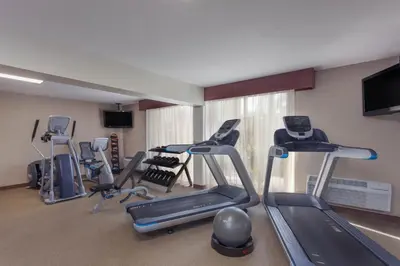 a gym with several tread machines in a room at Wyndham Visalia in Visalia