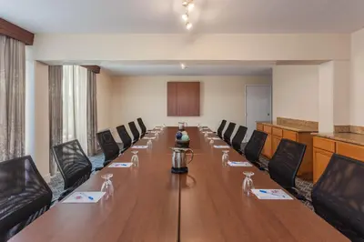 a conference room with a long table and chairs at Wyndham Visalia in Visalia