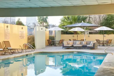 a pool with chairs and tables and umbrellas at DoubleTree by Hilton Fresno Convention Center in Fresno