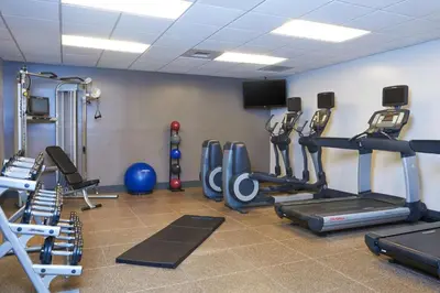 a gym with several tread machines and a flat screen tv at DoubleTree by Hilton Fresno Convention Center in Fresno