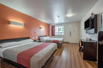 a room with two beds and a desk and a television at Motel 6-Fallon, NV in Fallon