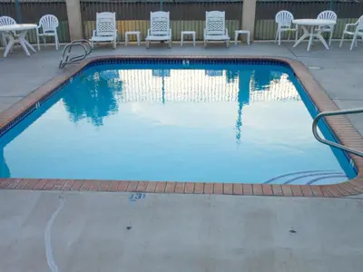 a swimming pool with chairs and tables and chairs at Motel 6-Fallon, NV in Fallon