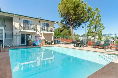 a swimming pool in front of a house at Best Western Cedar Inn & Suites in Angels Camp