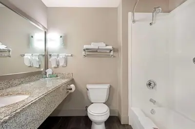 a bathroom with a toilet and a sink and a tub at Best Western Cedar Inn & Suites in Angels Camp