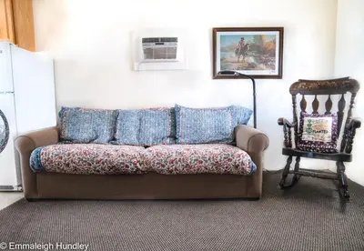 a couch in a living room with a lamp and a chair at Mt Williamson Motel and Basecamp in Independence