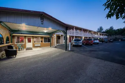 a building with cars parked in a parking lot at Angels Inn in Angels Camp