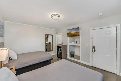 a small bedroom with two beds and a door at Rodeway Inn Stockton Highway 99 in Stockton