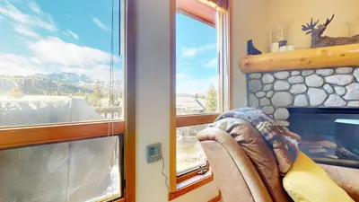 a room with a window and a chair and a fireplace at Snowcreek V #997 Condo in Mammoth Lakes