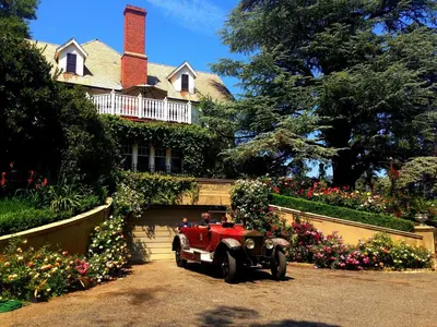 an old red car parked in front of a house at The Inn on Knowles Hill Bed & Breakfast Hotel in Sonora