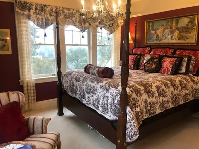 a bedroom with a four poster bed and a chandelier at The Inn on Knowles Hill Bed & Breakfast Hotel in Sonora