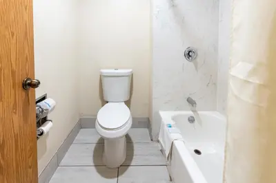 a bathroom with a toilet and a sink and a tub at Budget Inn Corcoran Near Tulare CA 43 in Corcoran