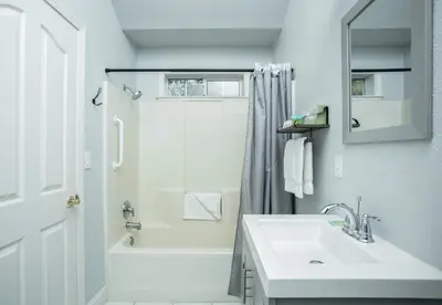 a white bathroom with a sink and a shower at Hounds Tooth Inn in Oakhurst
