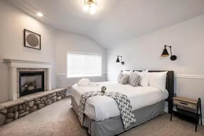 a bedroom with a large bed and a fireplace at Hounds Tooth Inn in Oakhurst