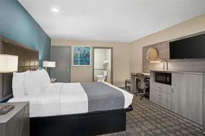 a hotel room with a bed and a flat screen tv at Best Western Big Country Inn in Coalinga