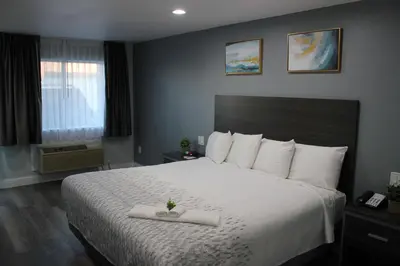 a bedroom with a large bed with white sheets at SureStay Hotel by Best Western Chowchilla Yosemite in Chowchilla