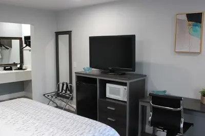 a bedroom with a bed and a television on a cabinet at SureStay Hotel by Best Western Chowchilla Yosemite in Chowchilla