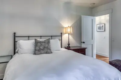 a bedroom with a large white bed and a lamp at Lake Front Family Home at Donner in Truckee