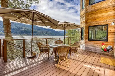 a wooden deck with a table and chairs and umbrella at Lake Front Family Home at Donner in Truckee