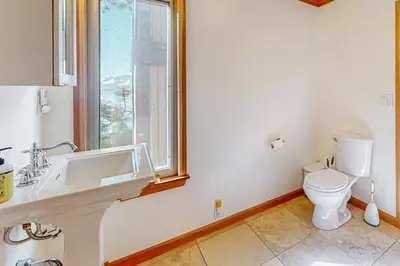 a bathroom with a toilet and a sink and a window at The Lake Labyrinth in Zephyr Cove