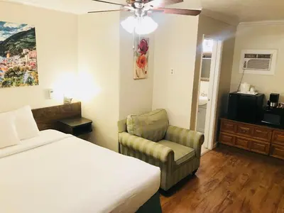 a hotel room with a bed and a chair at El Dorado Motel in Twain Harte