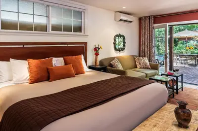 a bedroom with a large bed and a living room at Eden Vale Inn in Placerville