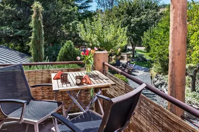 a wooden table and chairs on a balcony with flowers at Eden Vale Inn in Placerville