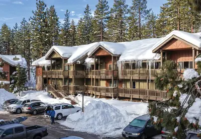 a lodge in the snow with cars parked in a parking lot at WorldMark South Shore in Zephyr Cove