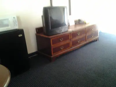 a tv sitting on top of a wooden dresser at Budget Inn in Tulare
