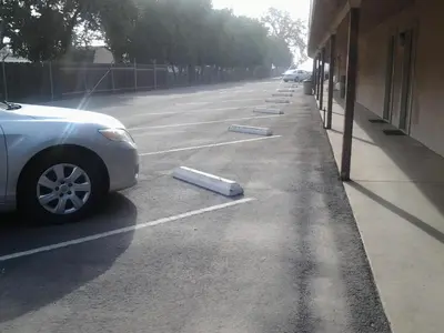 a car parked in a parking lot next to a building at Budget Inn in Tulare