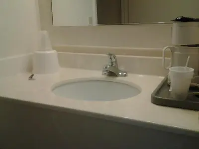 a bathroom counter with a sink and a mirror at Budget Inn in Tulare