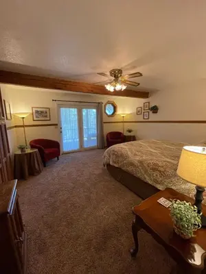 a bedroom with a bed and a couch and a window at Berkshire Inn in Groveland
