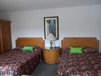two beds in a hotel room with green pillows at Atomic Inn Beatty Near Death Valley in Beatty