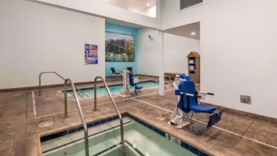 a swimming pool with blue chairs in a room at Best Western I-5 Inn & Suites in Lodi