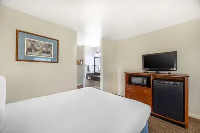 a hotel room with a bed and a flat screen tv at Best Western Capital City Inn in Sacramento