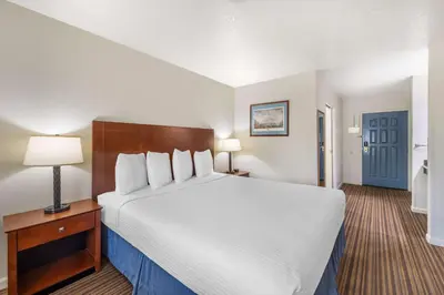 a hotel room with a large bed and a blue door at Best Western Capital City Inn in Sacramento