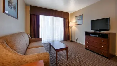 a living room with a couch and a flat screen tv at Best Western Capital City Inn in Sacramento