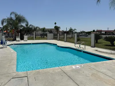 a large blue swimming pool in a yard at Motel 6-Delano, CA in Delano