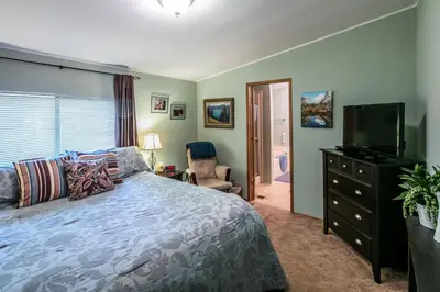 a bedroom with a bed and a flat screen tv at Yosemite Cabin in Wawona
