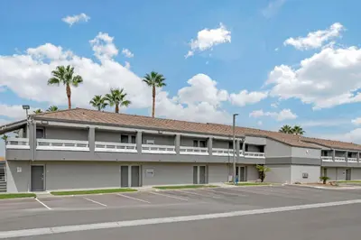 a building with palm trees in front of a parking lot at Quality Inn Kettleman City near Hwy 41 in Kettleman City