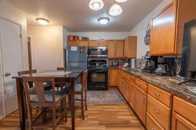 a kitchen with wooden cabinets and a table with chairs at Birch Creek #1 - 1BR/1BA - Down Canyon in June Lake