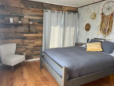 a bedroom with a bed and a wooden wall at McMillan Ranch Yosemite in Coarsegold