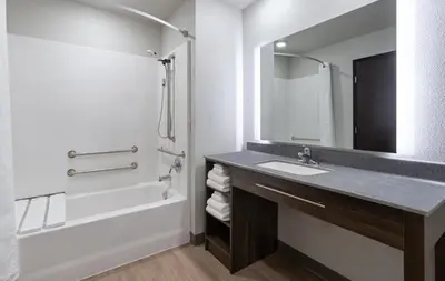 a bathroom with a sink and a tub and a mirror at My Place Hotel-Carson City, NV in Carson City