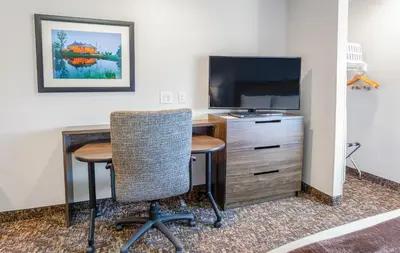a room with a desk and a tv and a table and chairs at My Place Hotel-Carson City, NV in Carson City