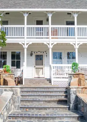 a white house with stairs in front of it at Inn at Sugar Pine Ranch in Groveland