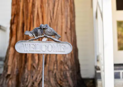 a welcome sign with two birds on top of it at Inn at Sugar Pine Ranch in Groveland
