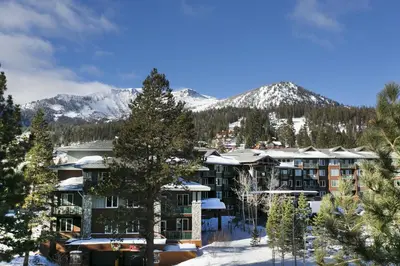 a resort with snow covered mountains in the background at Summit by 101 Great Escapes in Mammoth Lakes