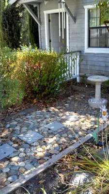 a house with a stone walkway in front of a yard at Mother Lode Lodge in Mariposa