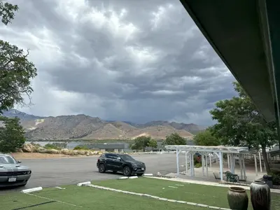 a car parked in a parking lot with mountains in the background at Lakeshore Lodge in Wofford Heights