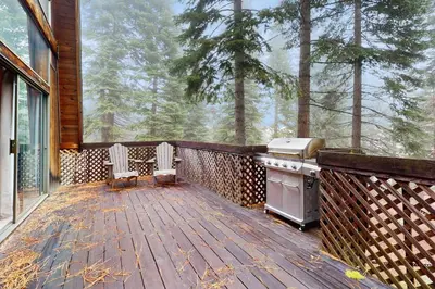 a screened in porch with a stove and chairs on a deck at Retro Family Gathering Home in Tahoe Donner in Truckee